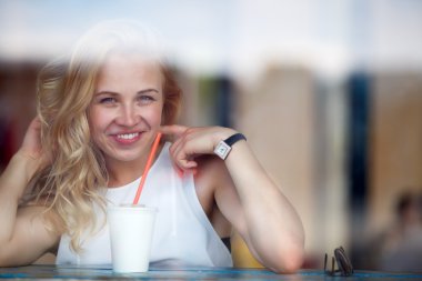 Kafede oturan uzun dalgalı saçlı neşeli sarışın kadın