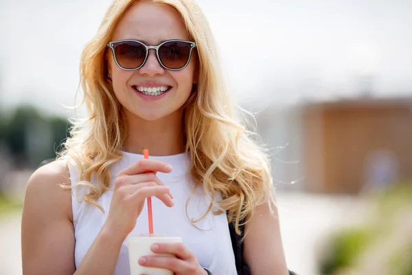 Porträt einer blonden Frau mit Sonnenbrille und Milchshake — Stockfoto