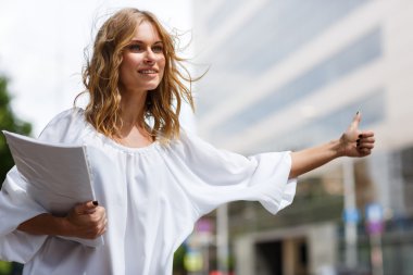 Bir taksi alarak belgelerle sarışın kadın