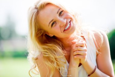 Parkta oturan uzun sarı saçlı sevimli kadın