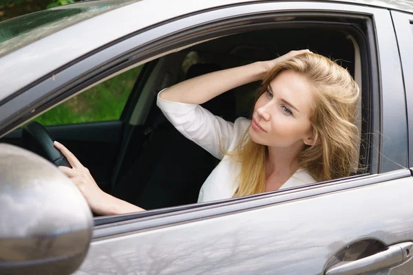 Mujer sonriente sentada en el coche —  Fotos de Stock