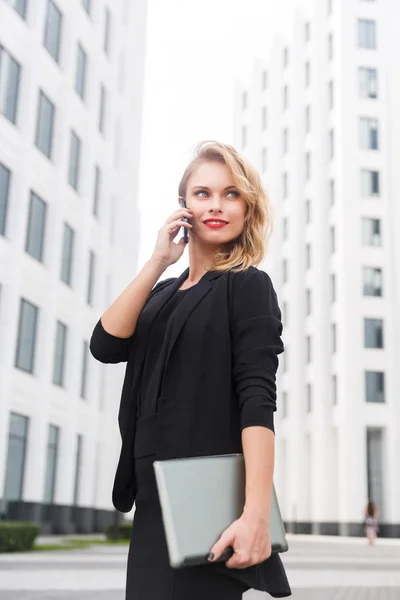 Usměvavá mladá obchodní lady v obleku s smartphone a laptop — Stock fotografie