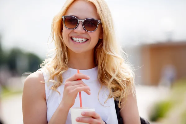 Mujer rubia alegre en gafas de sol con taza de bebida — Foto de Stock