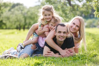 Çimenlerin üzerinde parkta oynarken aile