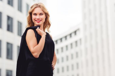 Binalar zemin üzerine sarı saçlı çekici gülümseyen kadın