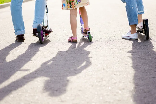 Föräldrar och barn står med skotrar. — Stockfoto