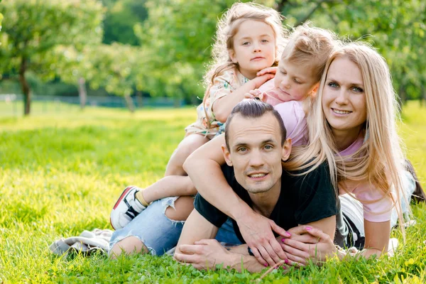 Jeune famille allongée sur l'herbe à la campagne — Photo