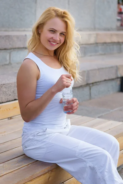Белая блондинка с бутылкой воды — стоковое фото