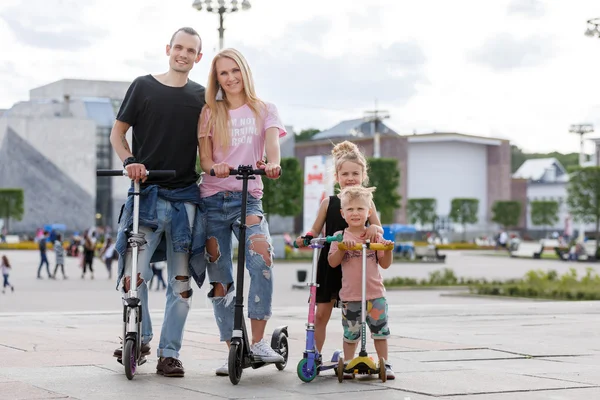 Family with scooters in the park — Stock Photo, Image