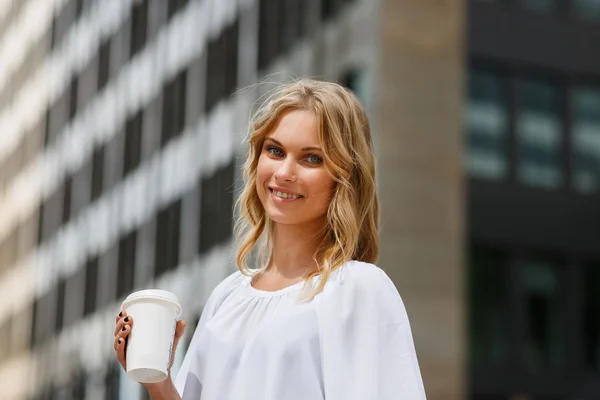 Portrait of smiling blond woman on business center background — Stock Photo, Image