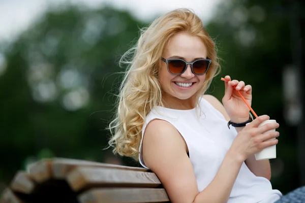 Młoda piękna uśmiechający się blond kobieta ze świeżego mleka koktajl — Zdjęcie stockowe