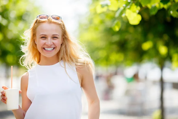 Smiling girl with milkshake outdoors — Stock Photo, Image