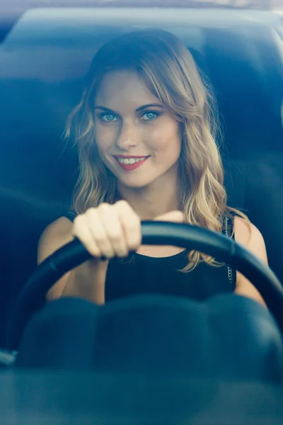 Uśmiechnięta kobieta za kierownicą samochodu, kompozycja pionowa — Zdjęcie stockowe