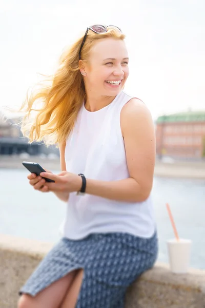 Retrato de hermosa rubia con teléfono en el paseo marítimo — Foto de Stock