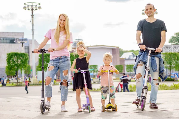 Young modern family with scateboard scooter. — Stock Photo, Image