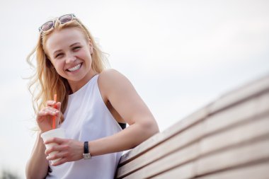 Uzun dalgalı sarı saçlı oturan ve bankta oturan kadın