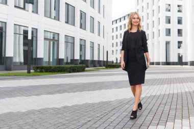 Beyaz ofis binası arka plan üstünde defter ile kendine güvenen iş kadını