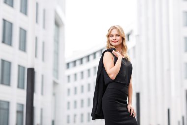 Sarışın Bayan siyah bluz ve etek office ayakta