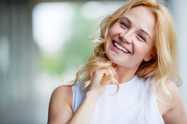 Portrait of smiling beautiful young woman touching her hair — Stock Photo, Image