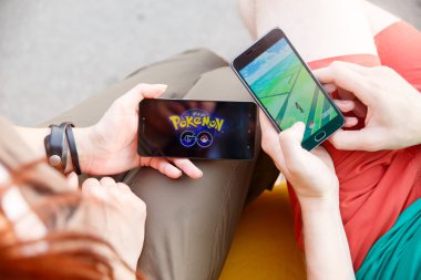 İlk adam onun perde ile Pokemon gitmek app, gösterilen elinde telefon düzenlenen ikinci bu uygulamayı yüklemek.