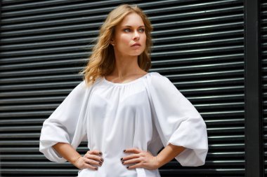 Yarı-büyüme elle duvar arka plan üzerinde akimbo kadında