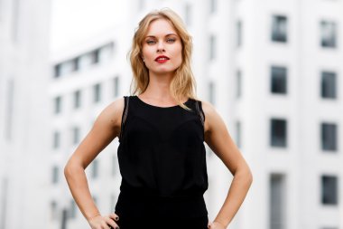 Kendine güvenen iş kadını sarışın kıvırcık saçlı açık havada portresi