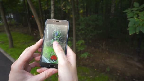 Mann spielt Pokemon Go Anwendung der Hit Augmented Reality Smartphone App beim Versuch, Pokemon zu fangen. — Stockvideo