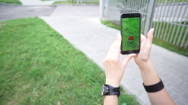 Perempuan yang sedang memainkan aplikasi Pokemon GO aplikasi telepon cerdas realitas teraugmentasi - menangkap Pokemon Drowzee . — Stok Video