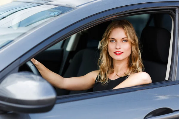 Hermosa mujer rubia joven caucásica sentada detrás del volante del coche —  Fotos de Stock