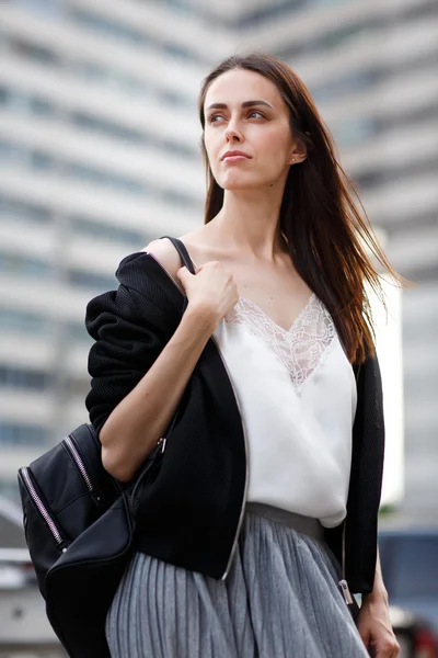 Na zewnątrz portret brunetka kobieta z torbą na ramieniu — Zdjęcie stockowe
