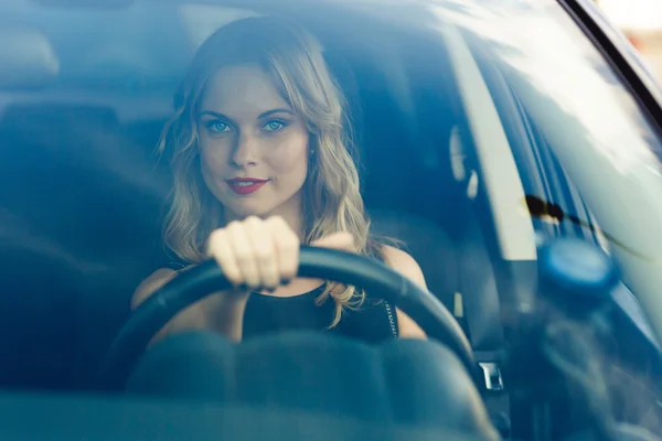 Mulher loira jovem bonita no carro ao volante — Fotografia de Stock