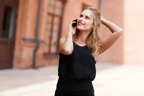Dreamy stylish caucasian woman talking on smartphone and looking up — Stock Photo, Image