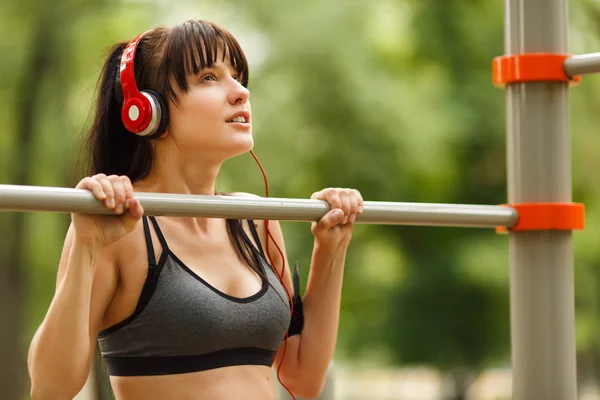 Mladá bruneta žena poslouchá hudbu a dělat cvičení — Stock fotografie