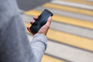 Erkek el ile boş perde smartphone yaya geçidi üzerinde tutarak