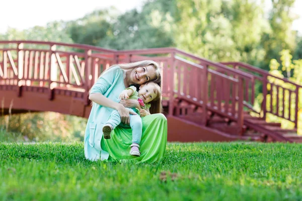 Mom gently hugs small daughter in park — Stock Photo, Image