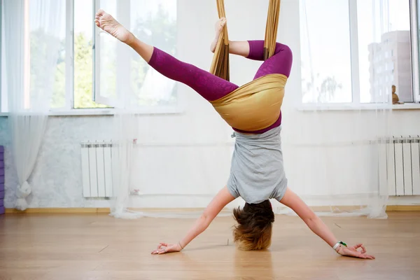 Menina caucasiana jovem posando ioga aérea com rede na classe — Fotografia de Stock
