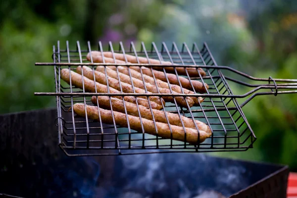 Salchichas apetitosas en la parrilla al aire libre — Foto de Stock