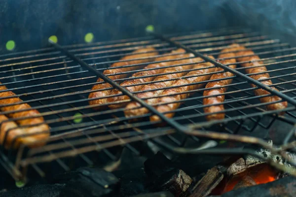 Barbacoa de verano en la naturaleza con jugosas salchichas a la parrilla — Foto de Stock