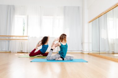 Duruş eka pada radzhakapotasana içinde oturan iki eğitmenler