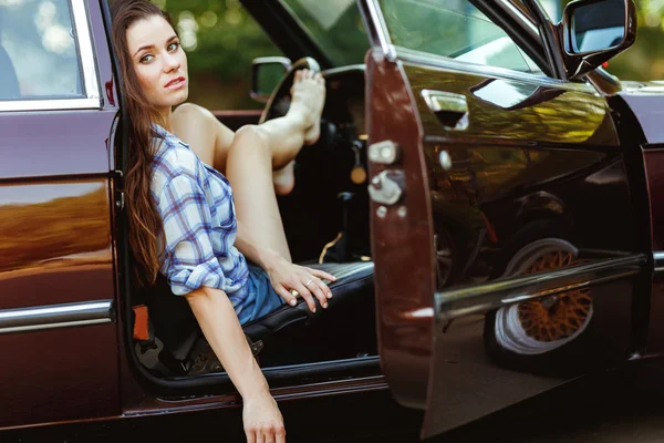 Mujer joven en coche de color burdeos, foto teñida —  Fotos de Stock