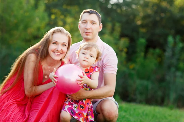 Portrait of cheerful family with little daughter on grass — Stock Photo, Image