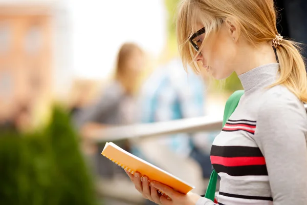 Chica mira en cuaderno en la calle — Foto de Stock