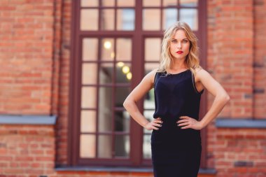 Kırmızı dudaklar ile zarif siyah elbiseli sarışın genç kadın