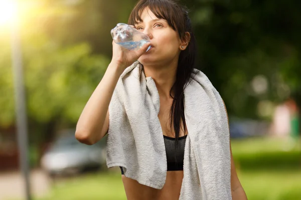 Фитнес молодая женщина отдыха и питьевой воды после тренировки — стоковое фото