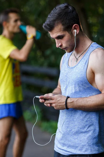 Two young athlete in park relaxing after workout — Stock Photo, Image