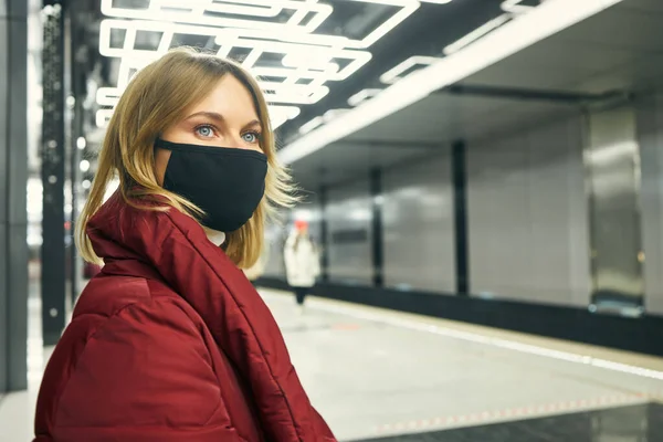 地下鉄でマスクと赤いコートの女性 — ストック写真
