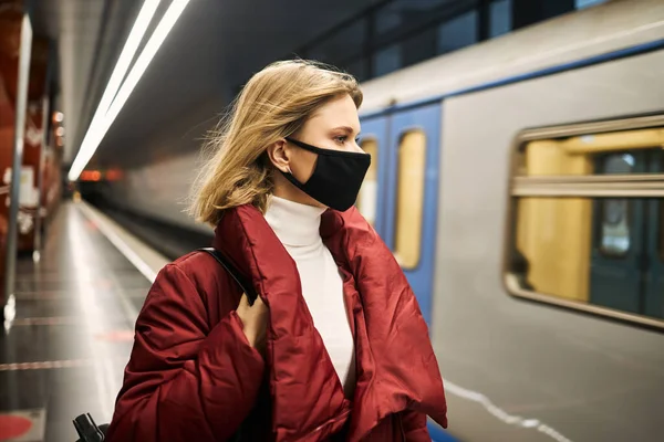 Wanita bertopeng dan mantel merah di kereta bawah tanah — Stok Foto