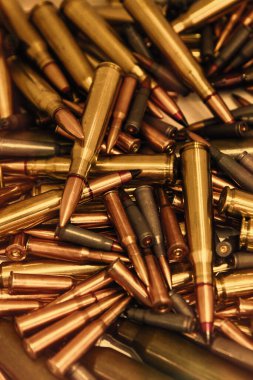 Sıcak bir ışık altında bakır uçlu mermi yığını. Bir sürü mermi yakın çekim. Amerika 'da silah şiddeti. Cephane tüfeği ya da tabanca. ses tonlu