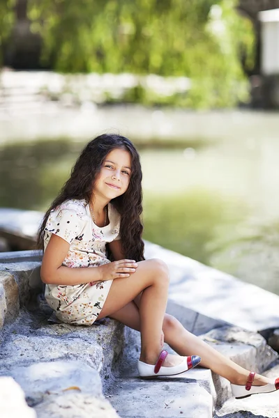 Parkta merdivenlerde oturan gülümseyen güzel kız