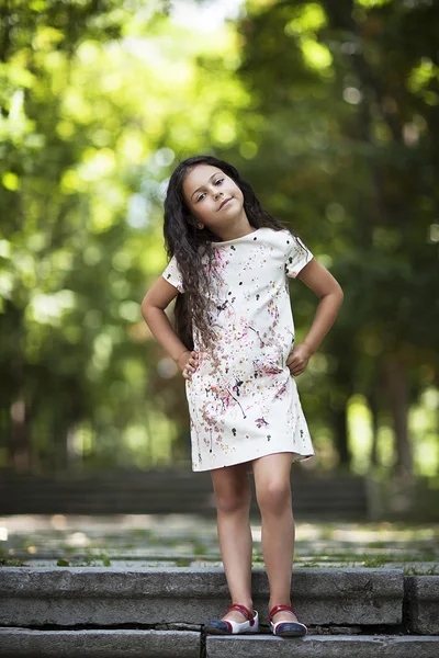 Menina bonita sorrindo de pé nas escadas do parque — Fotografia de Stock